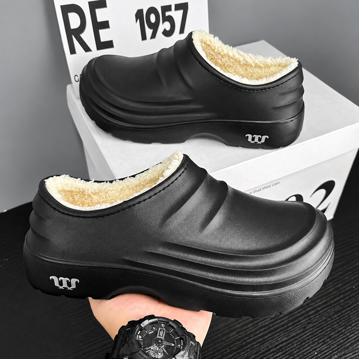 Rovelle Black plush lined clogs, side view of the pair showing the enclosed heel and sculpted EVA sole